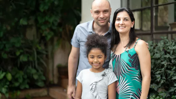 Young family, Mum Dad and daughter pose for a photograph