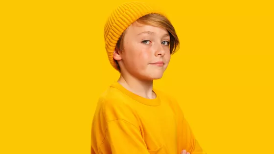 Cash smiling at the camera against a yellow background