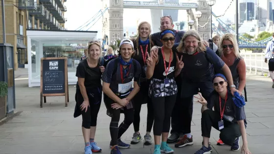 Group of walkers posing for a photo in front of Tower Bridge