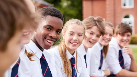 students in ties sitting on a wall