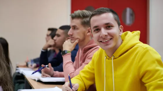 uni student in yellow jumper smiling