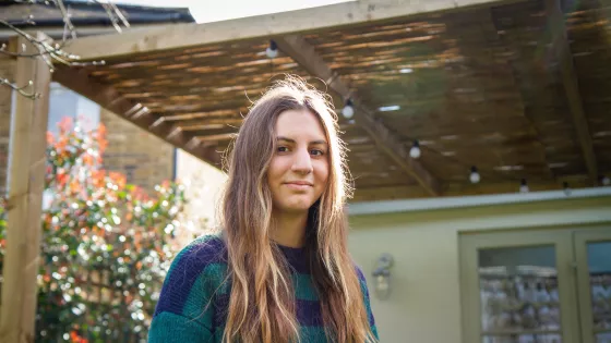 young girl staring down the camera with slight smile