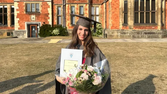 A young woman graduates university.