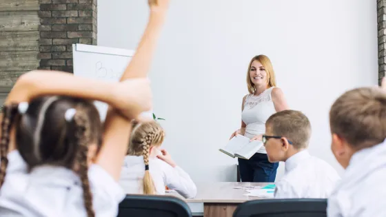 A teacher stands in front of a class of students.