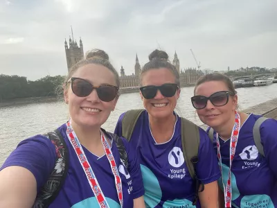 3 female friends posing for a photo with big ben and the Thames behind them