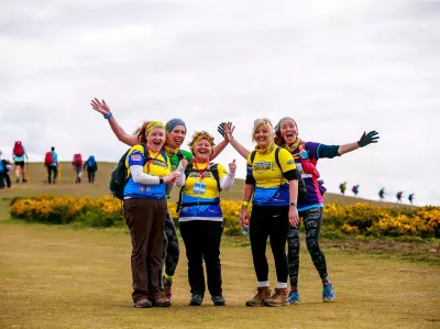 Group of walkers posing for a photo on a cliff top