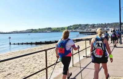 Ladies with back packs walking along the sea front