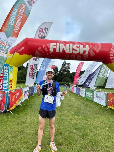 Smiling man with medal at finish line