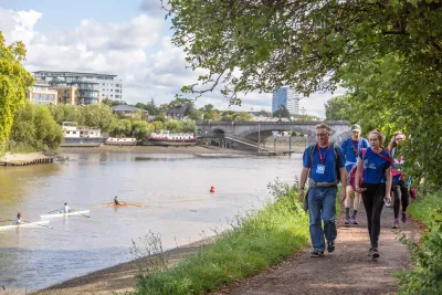 Walkers next to the Thames with a view of London in the background