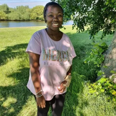 girl standing on a river bank smiling