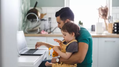 Father researching online with son on lap