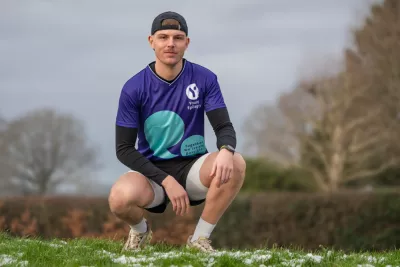 A young man poses in a Young Epilepsy t-shirt