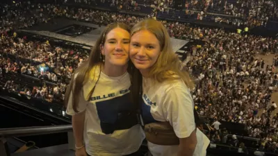 Two young girls pose for a photo at a concert