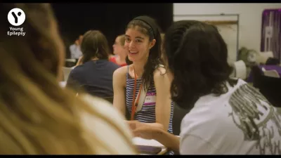 A young woman laughs amongst peers at a Youth Voice Roadshow.