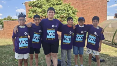 A group of boys link arms and smile in Young Epilepsy 'Purple Day' clothing.