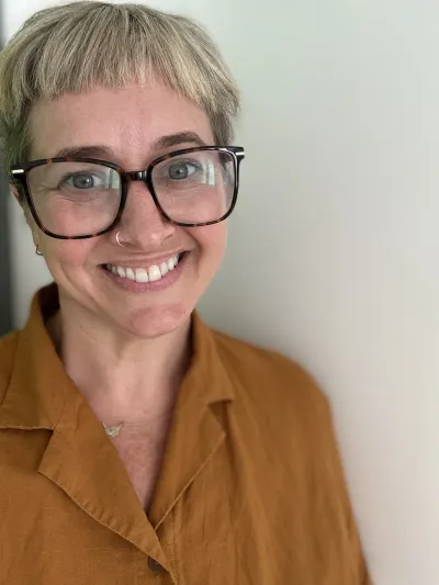 A healthcare professional smiles to camera.