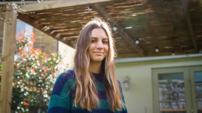 A young woman stands outside in a selfie.