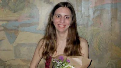 A young woman holds a bouquet of flowers.