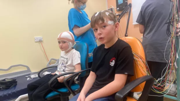 Young boy having an EEG with his sister for epilepsy diagnosis.