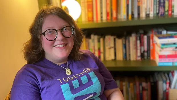 Annie smiling by a bookcase