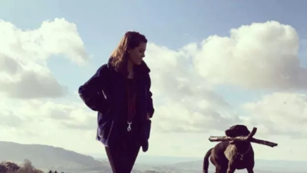 young girl walking her dog on a hill