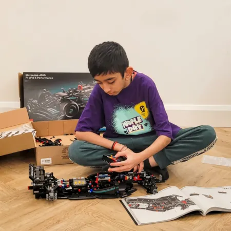 A boy in a Young Epilepsy t-shirt plays with Lego.