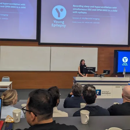A woman performs a lecture on Young Epilepsy research.