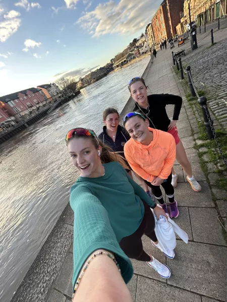 4 Women taking a selfie as they walk along a canal