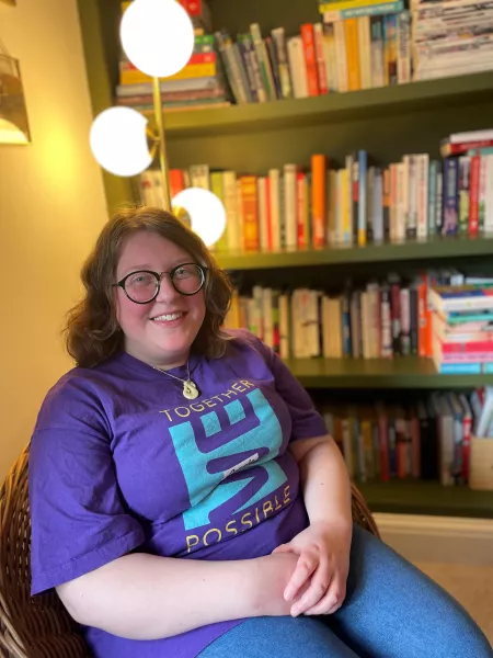 Annie smiling by a bookcase