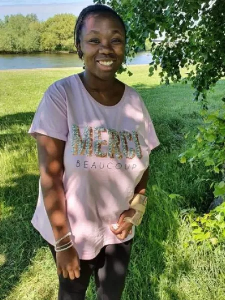 girl standing on a river bank smiling