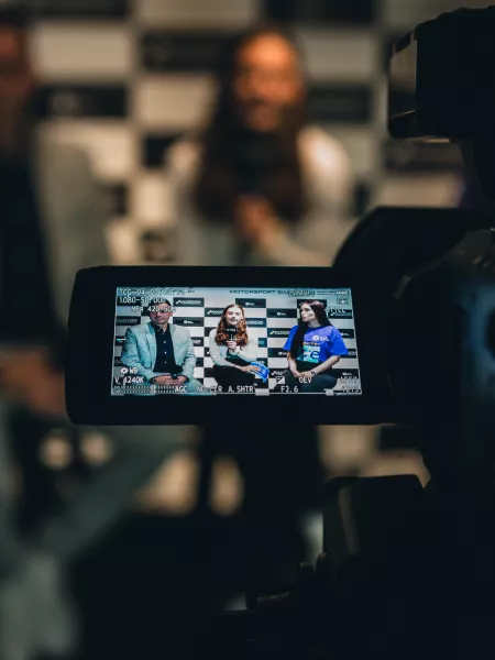 A camera is pointing at 3 people being interviewed