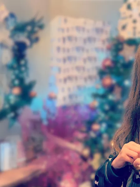 Young girl smiling next to a Christmas tree