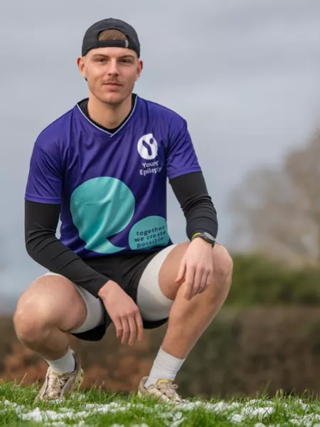 A young man poses in a Young Epilepsy t-shirt