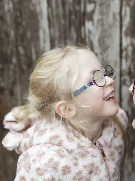 A mother and daughter smile at each other.