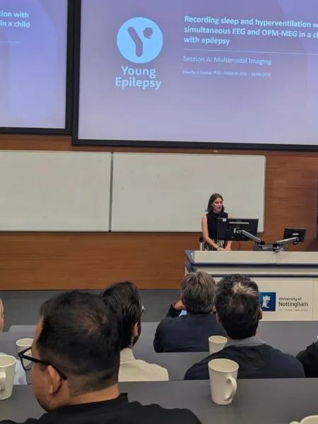 A woman performs a lecture on Young Epilepsy research.
